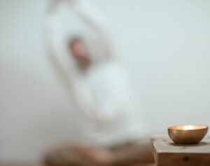 Calm scene with a singing bowl and blurred yoga pose, promoting tranquility.
